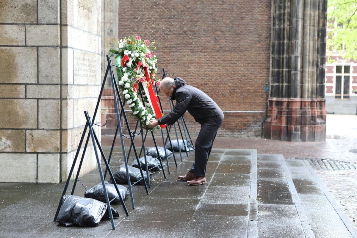 Vanwege de wind moesten medewerkers van de 4-mei Herdenking de kransen extra vastzetten. Foto: Ton van den Berg