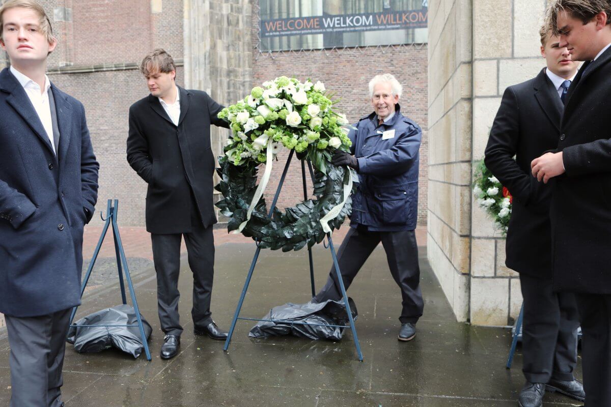 De krans van het Utrechts Studenten Corps moest worden vastgehouden vanwege de sterke wind. Foto: Ton van den Berg