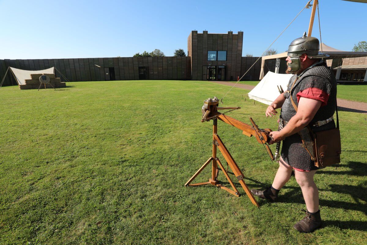 Zogeheten re-enactors van Pax Romana vuren een kopie van de gevonden ballistapijl af. Foto: Ton van den Berg