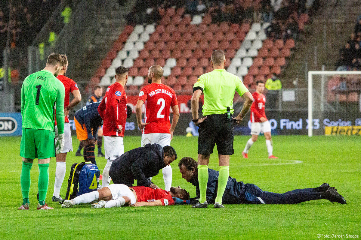 Mike van der Hoorn wordt behandeld op het veld. Hij verliet lopend het veld, maar moest voor onderzoek naar het ziekenhuis.