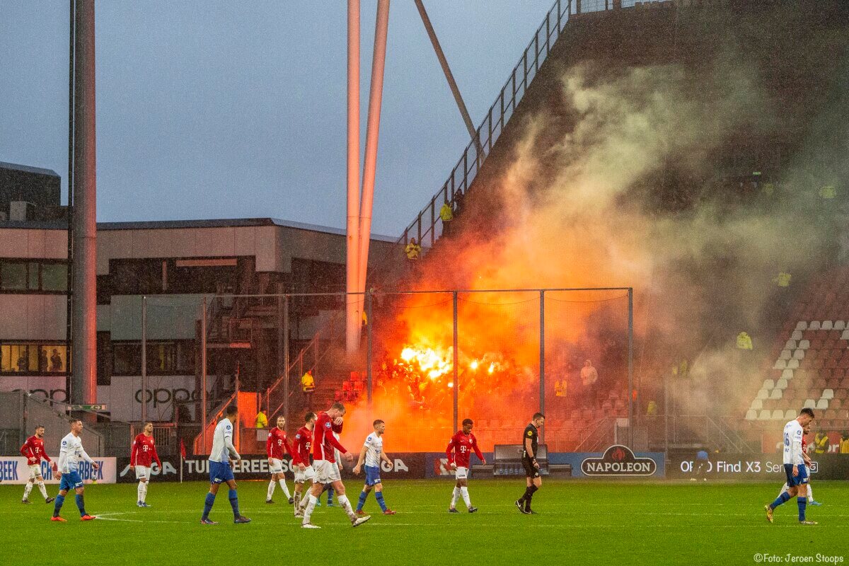 Vuurwerk in het Vitesse-vak. De wedstrijd wordt stilgelegd.