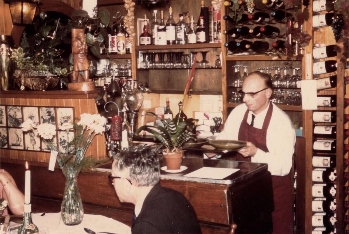 Piet Vroon met borden eten bij de bar. Foto: familie Vroon
