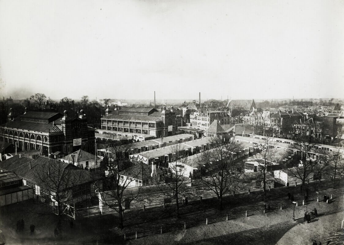 Een overzicht van het Vreeburg tijdens de eerste Jaarbeurs in 1917, gezien vanaf het torentje van het hotel Noord Brabant. Beide gebouwen waren toen in gebruik voor toonkamers en ook op het plein zelf bevonden zich de nodige houten noodgebouwen voor toonkamers. Zelfs dit bleek destijds nog te weinig en zodoende werden er ook op het Janskerkhof en de Maliebaan nog noodgebouwen neergezet. Een jaar later zou dit nog eens uitgebreid worden met een terrein aan de noordzijde van de Kanaalstraat. (HUA403254)