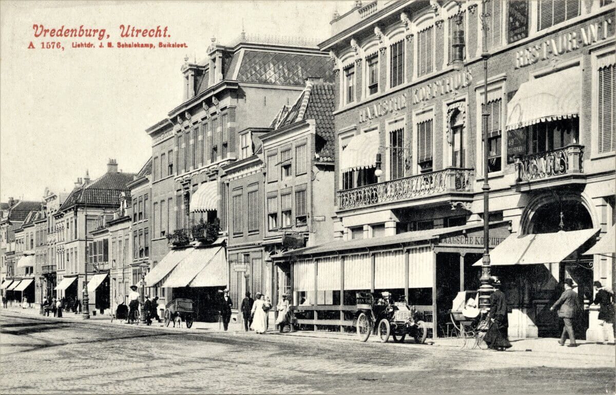 Ik kan deze foto redelijk precies dateren. Omdat het terras uitstaat weten we dat het tijdens de kermis moet zijn en verder zien we al wel lantaarnpalen met zogenoemde booglampen staan. Elektrisch licht, waar men in 1906 juist op die plek een proef mee startte. Er is nog geen bovenleiding voor een elektrische tram te zien. Deze ging daar pas in 1907 rijden, dus de foto moet gemaakt zijn in juli 1906. Een leuk detail is de auto die voor het 'Haagje' geparkeerd staat. Aan de hand van het kenteken (G562) kunnen we vaststellen dat de heer Hendrik Gerrit Koning uit Amsterdam op dat moment waarschijnlijk even van een uitgebreide lunch aan het genieten is. Het kenteken kreeg hij overigens toegewezen per 6 april 1906 dus dat klopt ook bij het dateren van deze foto. (HUA4996)