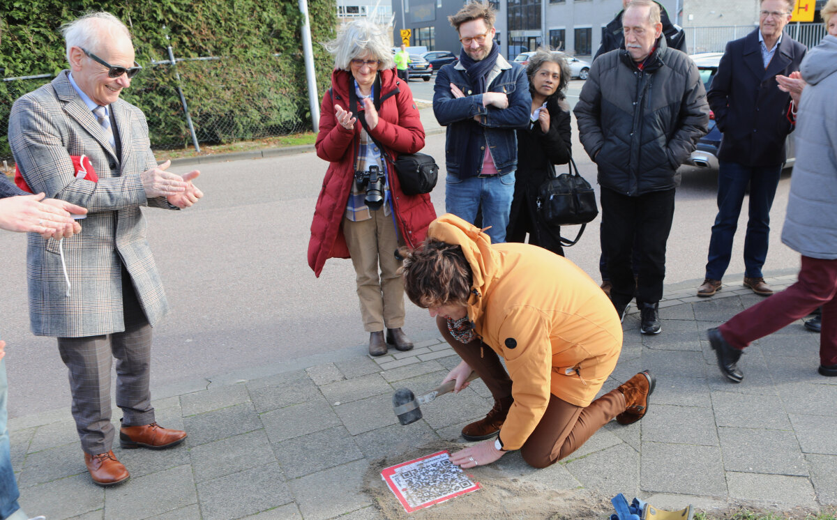 Wim van Scharenburg (Museum van Zuilen) applaudiseert voor het leggen van de stoeptegel met QR-code. Foto: Ton van den Berg