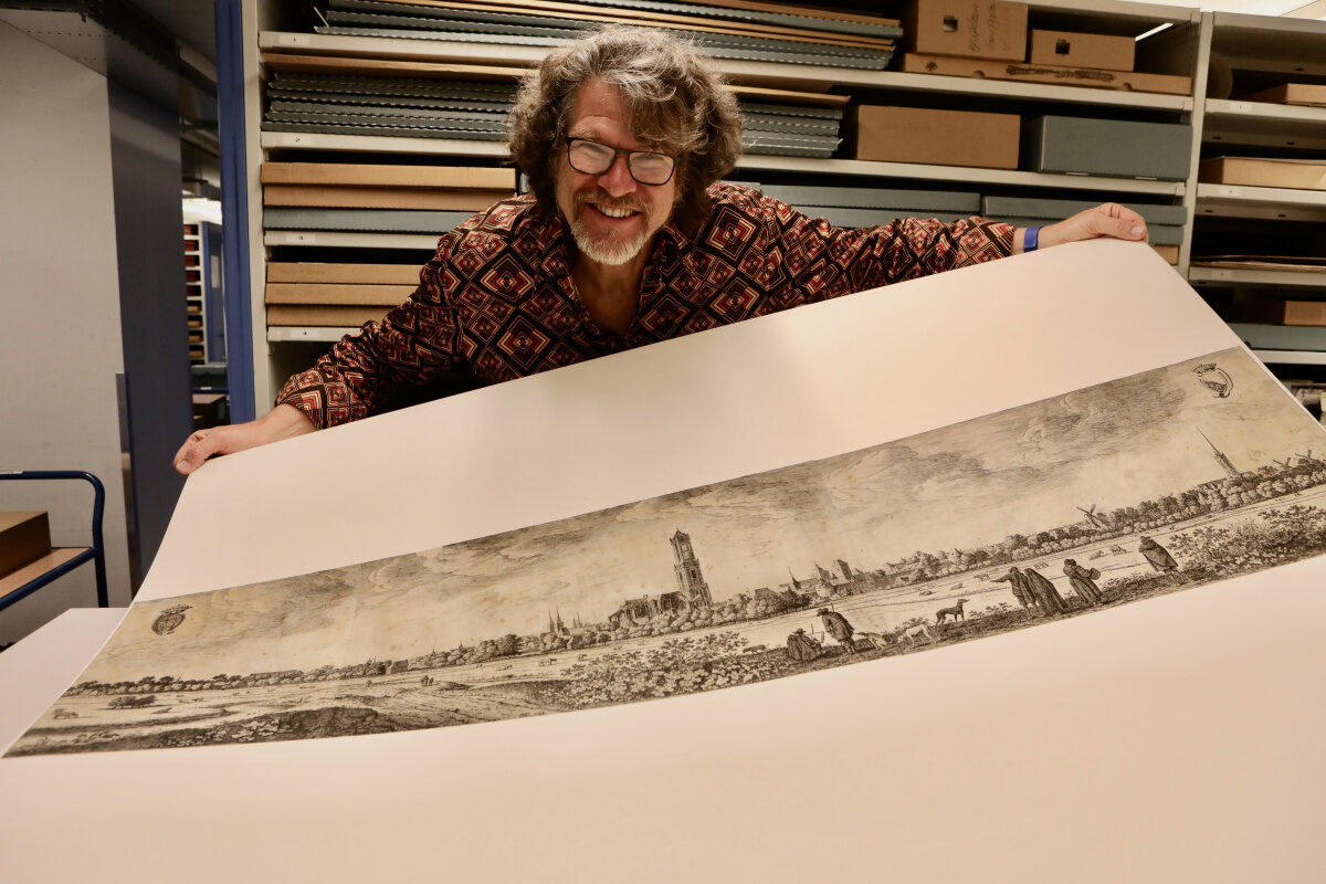 Van Rossem met de ets uit 1648 met het panorama van Utrecht getekend door Saftleven. Foto: Ton van den Berg