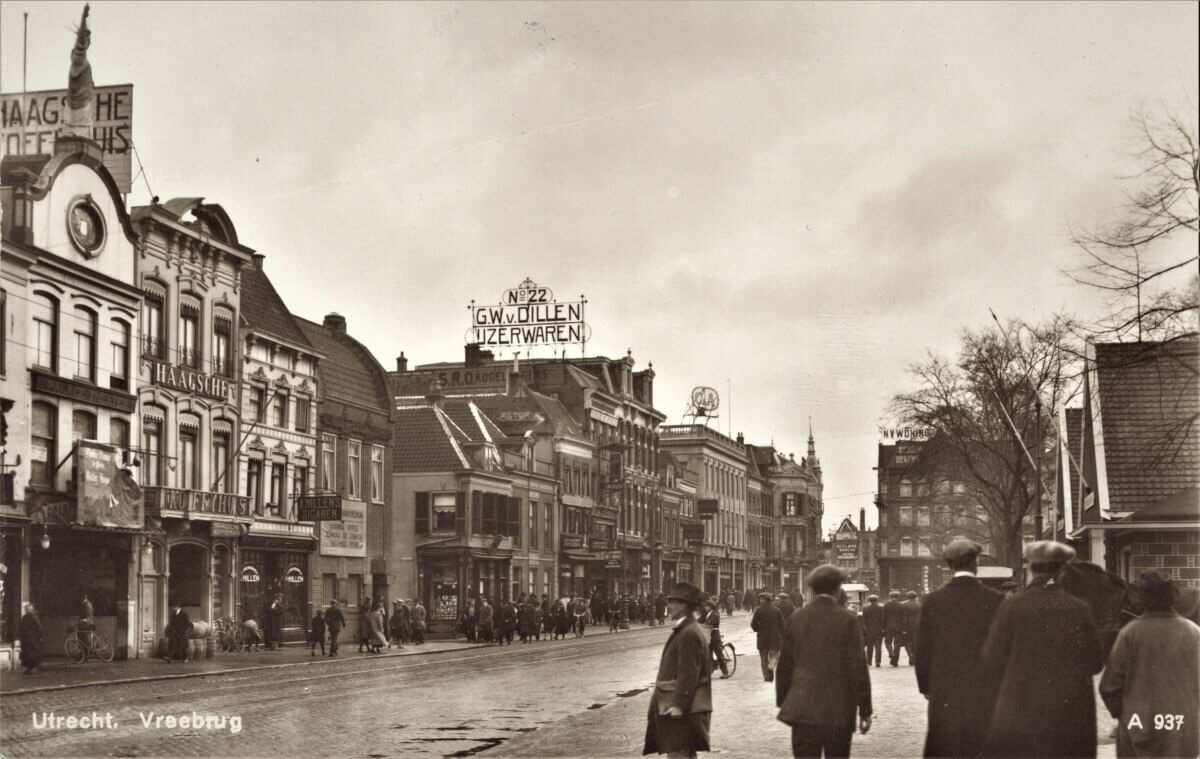 De noordzijde van het Vredenburg rond 1927 met in het midden de winkel van de fa. G.W. Van Dillen Jr. met de toentertijd iconische reclame op het dak. Een stukje verderop zien we dat het grote Haagsche Koffiehuis inmiddels veranderd is in de moderne modewinkel van C&A en links op de foto zien we de nieuwe veel kleinere vestiging van het Haagsche Koffiehuis. Afbeelding: HUA