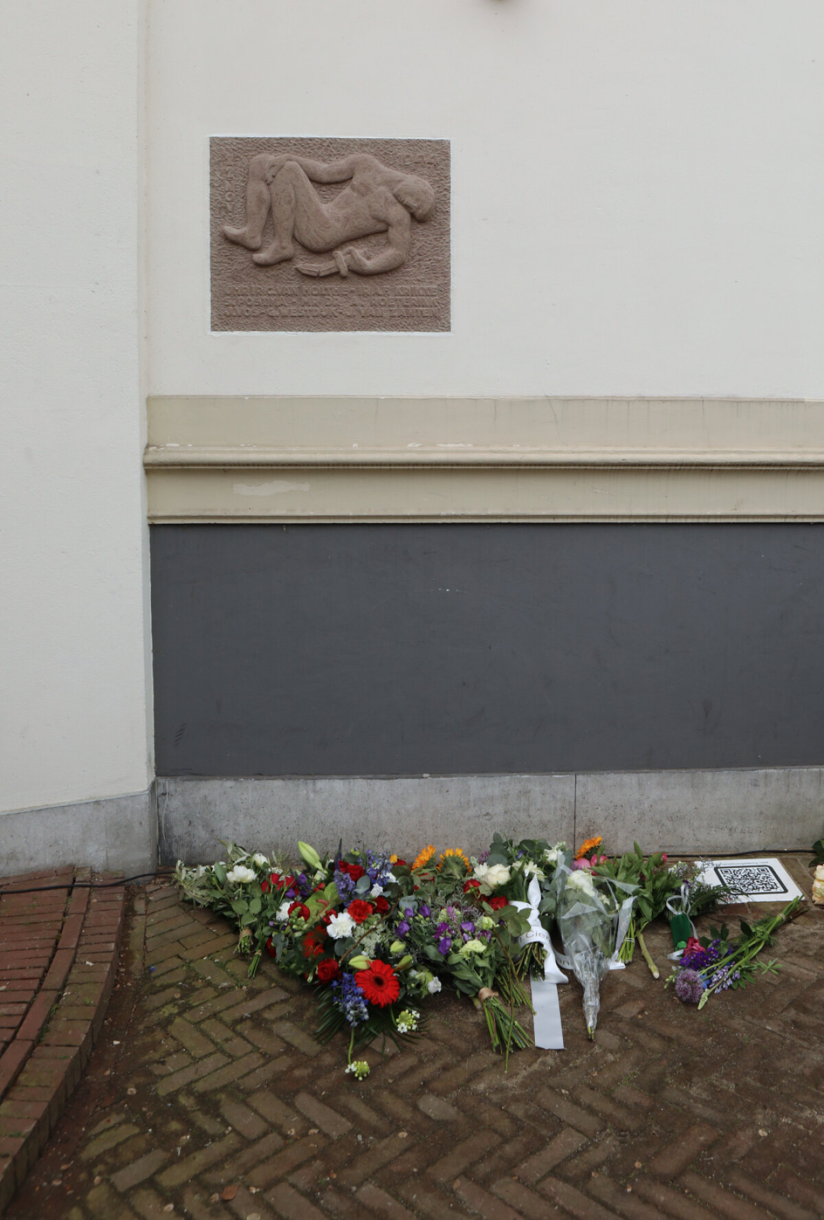De gedenksteen met bloemen van familie en vrienden van de slachtoffers. Foto: TvdB