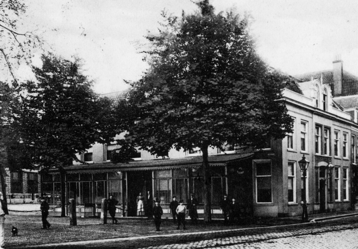 Zo zag het hotel eruit rond 1895. We kijken op de oostzijde, waartegen in 1878 de warande was aangebouwd. Rechts de nieuwe pui uit 1880, waarmee het dubbele pand definitief werd samengevoegd. Links in de 		achtergrond is nog een stukje van de Fruithal te zien, die in 1894 gereed kwam.