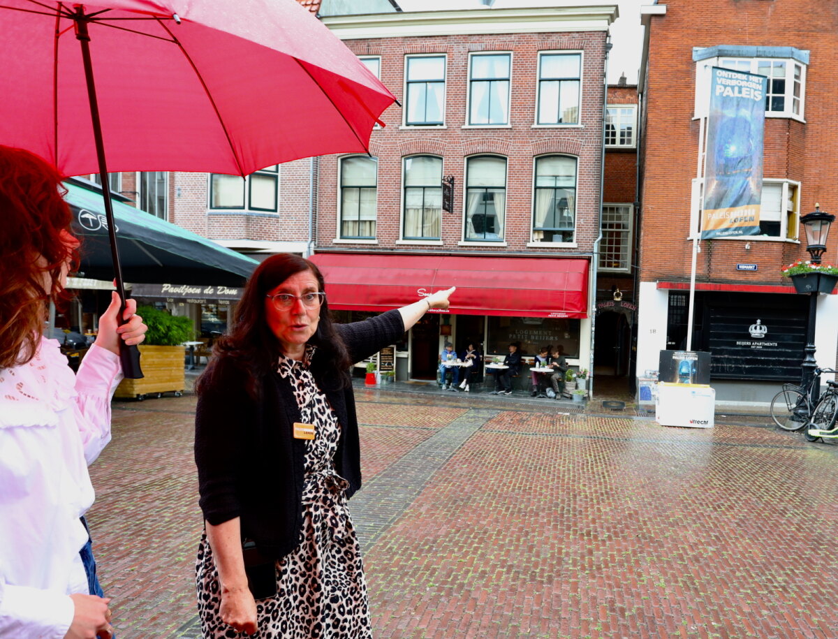 Gids Giovanna wijst naar het nauwe steegje dat toegang biedt tot de resten van paleis Lofen. Foto: Ton van den Berg