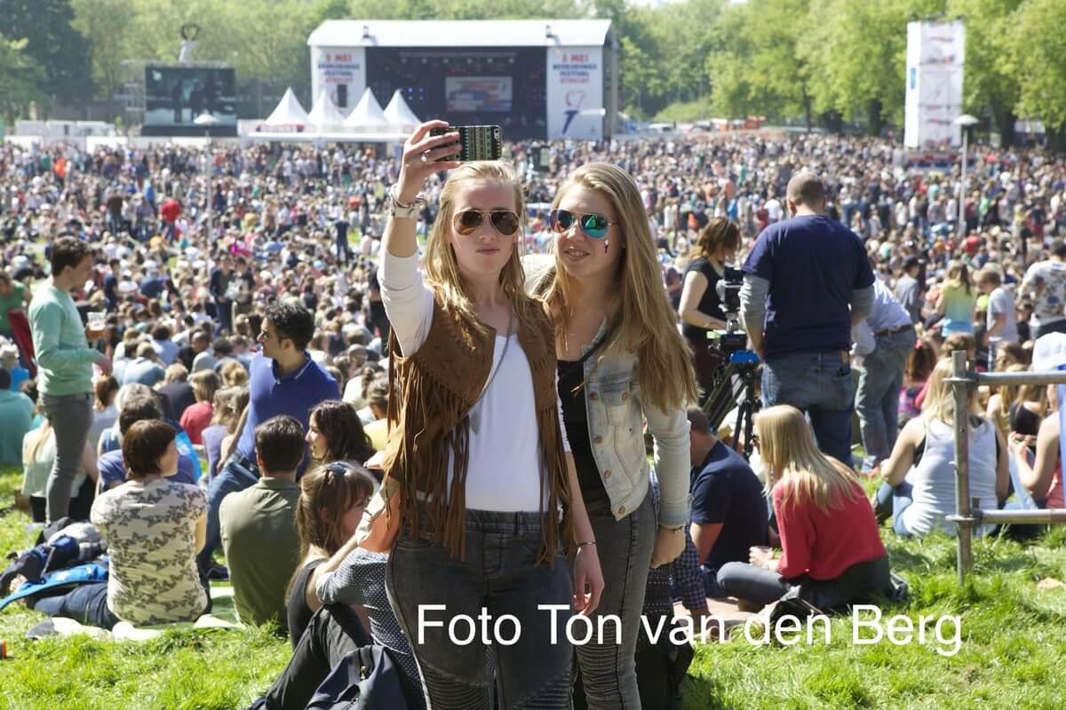 Duizenden bezoekers genieten van de zon.