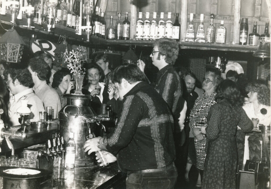 Achter de grote bar tapt Cor - Hoss - Keiman kleintjes pils en achter hem deejay Cees Versteeg. Foto: archief A. Kayim