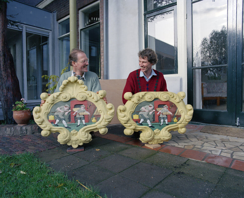 Bouwhistoricus Frans Kipp (links) met een replica van het gevelbord van bakkerij Top (Wittevrouwenstraat) in 1992. Rechts is het originele gevelbord. Foto: HUA