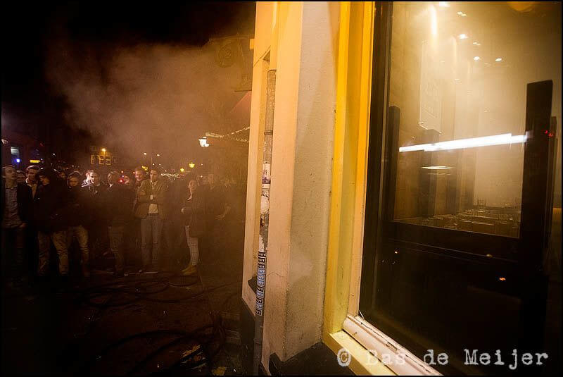 Gasten van het cafe wachten buiten af wat gaat gebeuren. Foto: Bas de Meijer