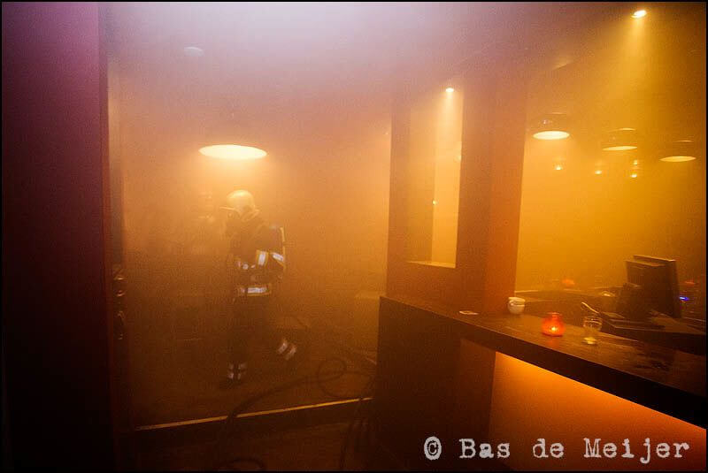 Een brandweerman loopt door het cafe. Foto: Bas de Meijer