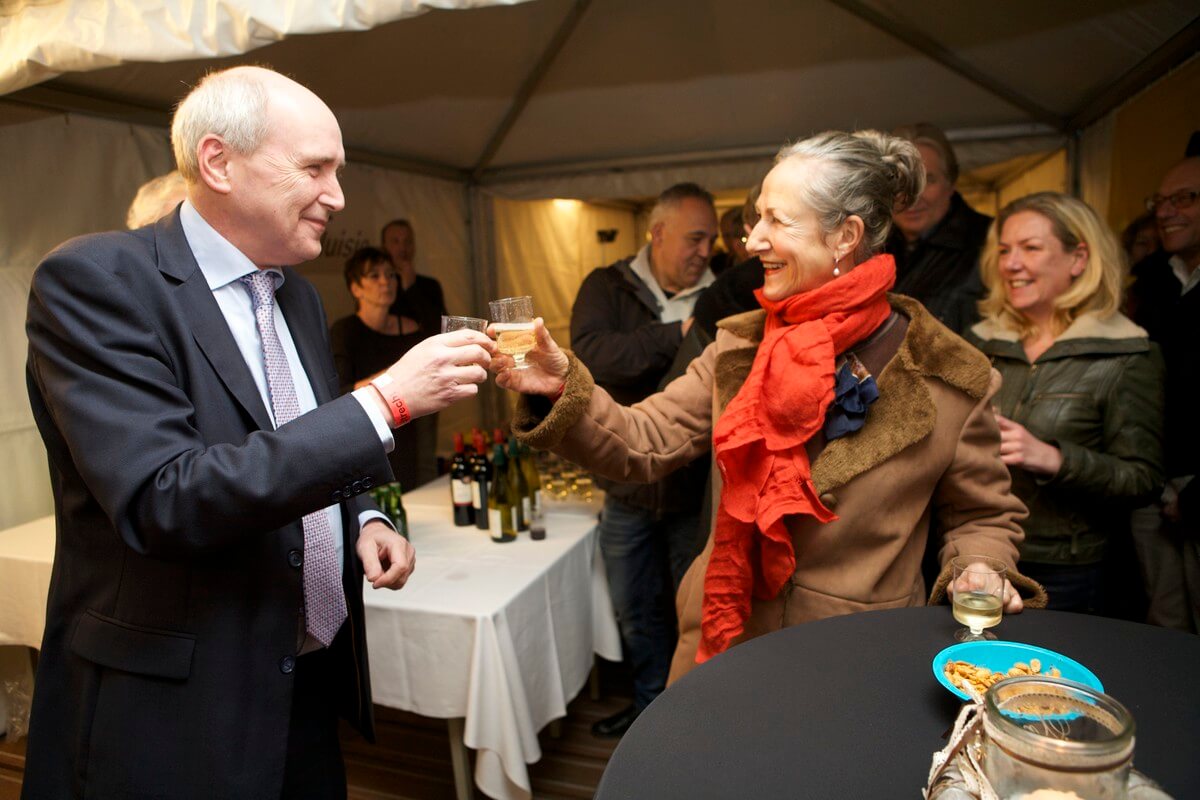 Wethouder Geldof proost met een van de buurtbewoners op het herstel van de kademuur. Foto: Ton van den Berg