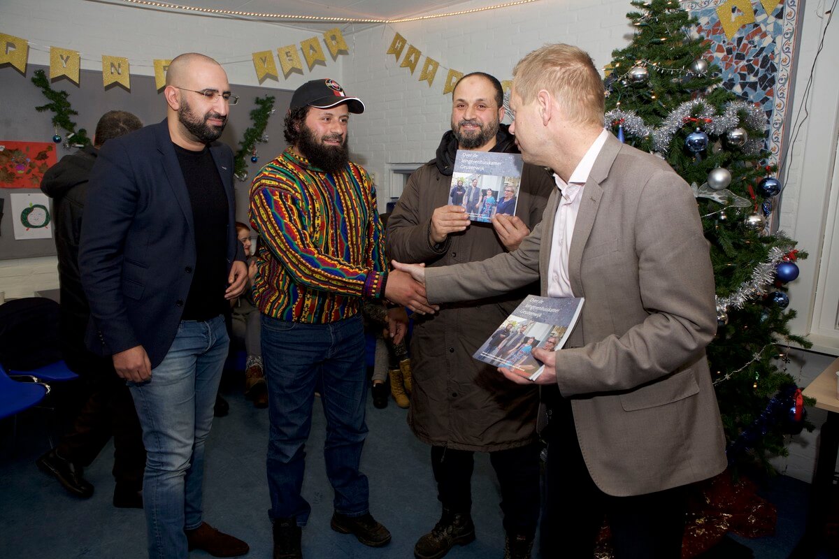 Wethouder Diepeveen deelt de eerste exemplaren van het boekje uit aan de hoofdrolspelers (vlnr) Rachid Habchi, Issa en Roela Ghoula. Foto: Ton van den Berg