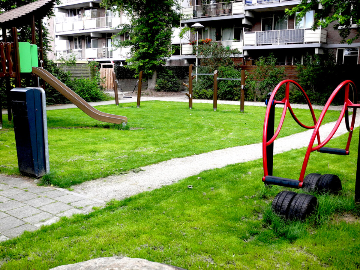Grasveldje met speeltoestellen: een rustig plekje in de stad.