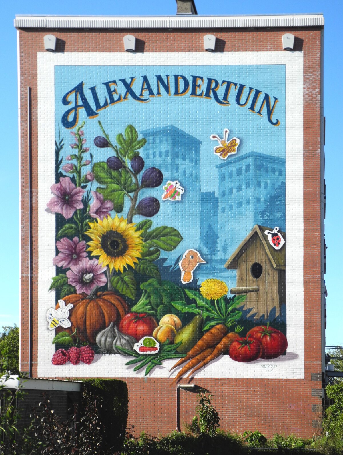 De Verfdokter zette bloemen, groenten en beestjes op de muur. Op de achtergrond de flats aan de Azi&euml;laan. Foto: Joost van Waert