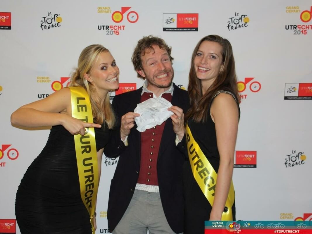 Dichter Alexis de Roode presenteert het zadelhoesje aan de Tourdames. Foto: Le Tour Utrecht