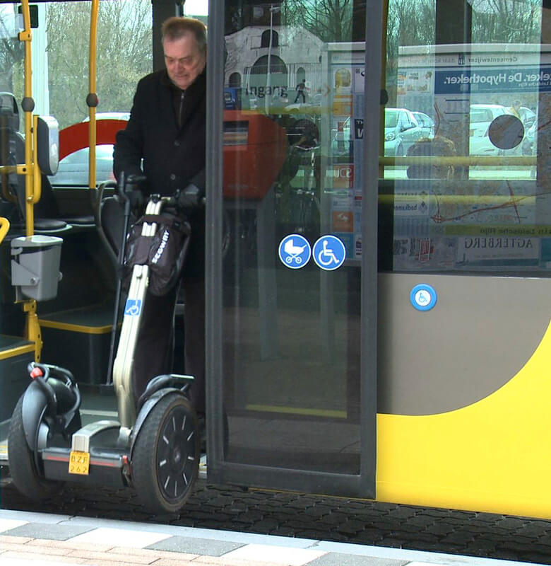 Frans Schuijt sjouwt zijn Segway de bus in.