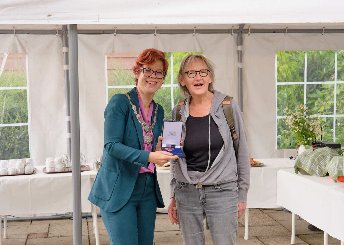 Wethouder Linda Voortman en Janne van Malenstein poseren met de medaille. Foto: Coen Koppen