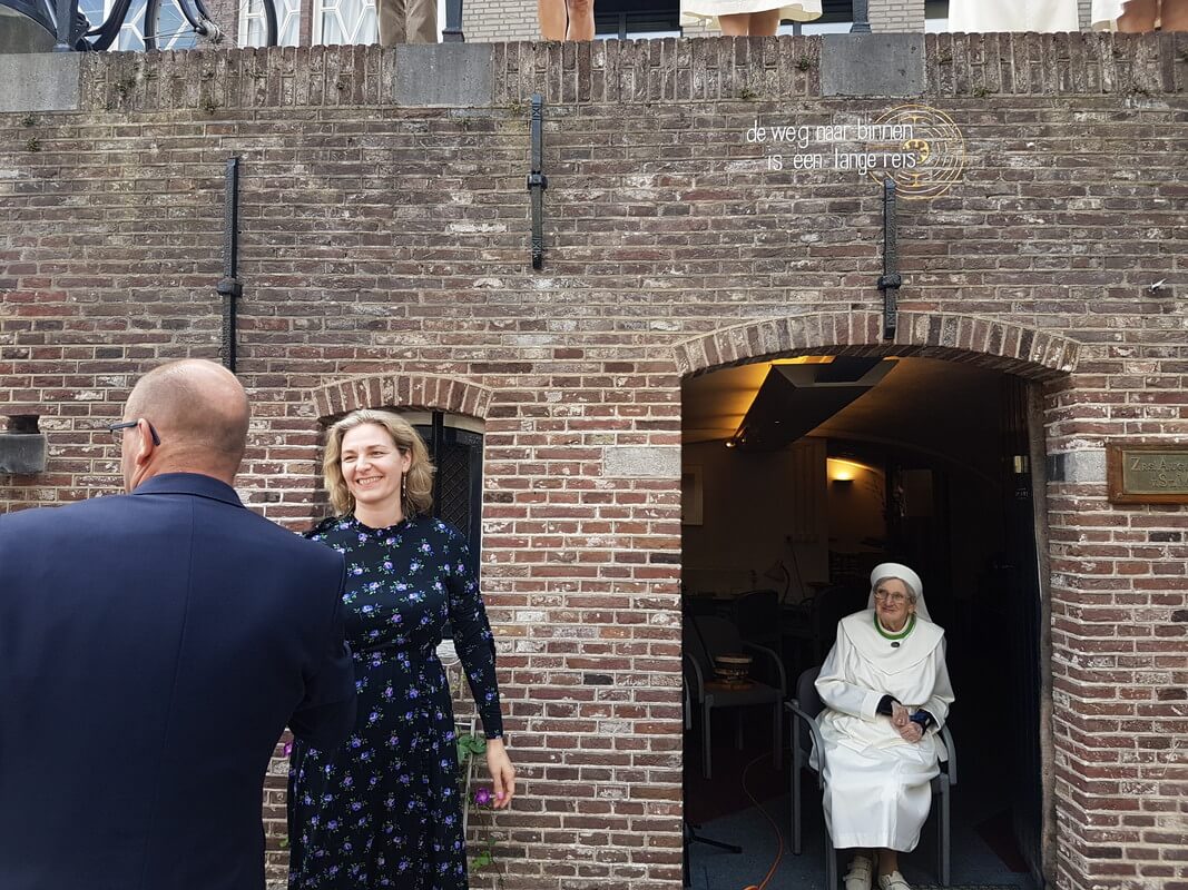 Boven de deur de aangebrachte tekst, met links ervan wethouder Anke Klein. Foto: Werkgroep Directe Voorzieningen