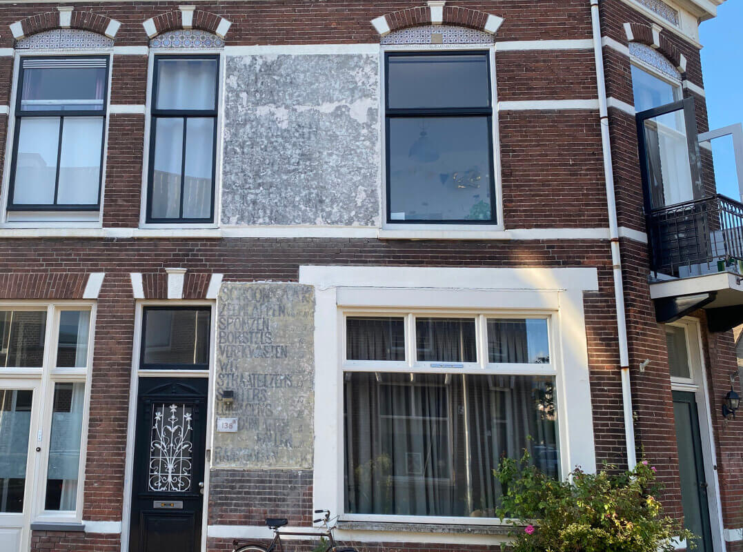 Twee vlakken met muurreclames aan de Abstederdijk-kant van het pand, augustus 2023. Foto: JT