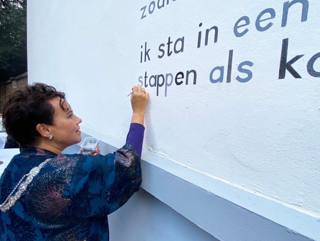 Burgemeester Sharon Dijksma schilderde bij wijze van onthulling een letter van het muurgedicht. Foto: Jim Terlingen