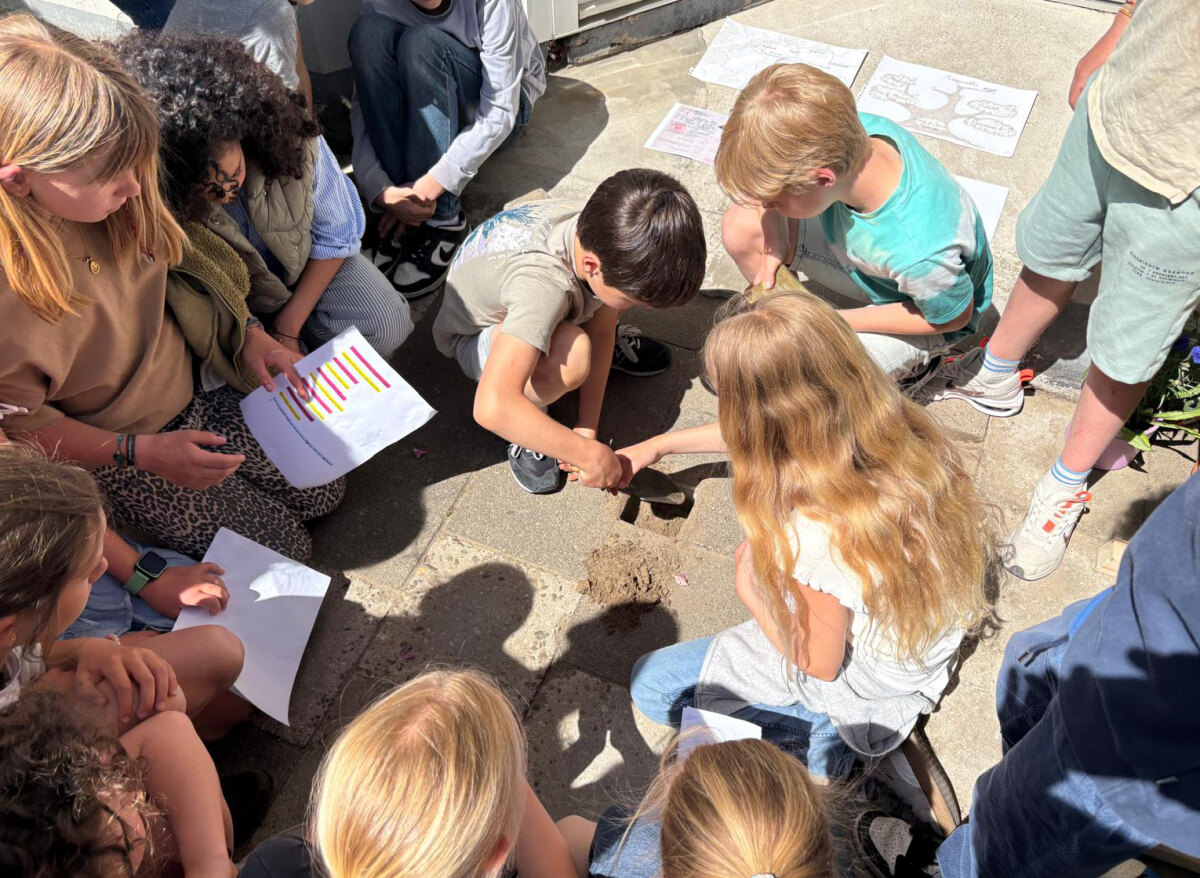 Kinderen uit groep 7 van de Koekoekschool leggen een struikelsteen op de Havikstraat. Foto: Noël van Rens