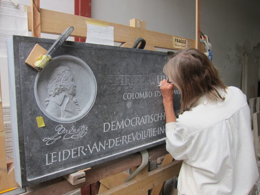 Britt Nelemans werkt aan de gevelsteen voor patriottenleider Pieter Quint Ondaatje. Foto: Paul Verhagen/UGTF.
