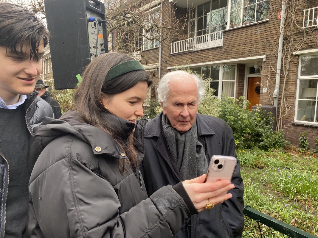 Achterkleinkinderen van Ernst Verloop (96) laten hem zien naar welke website de QR-code verwijst. Foto: JT