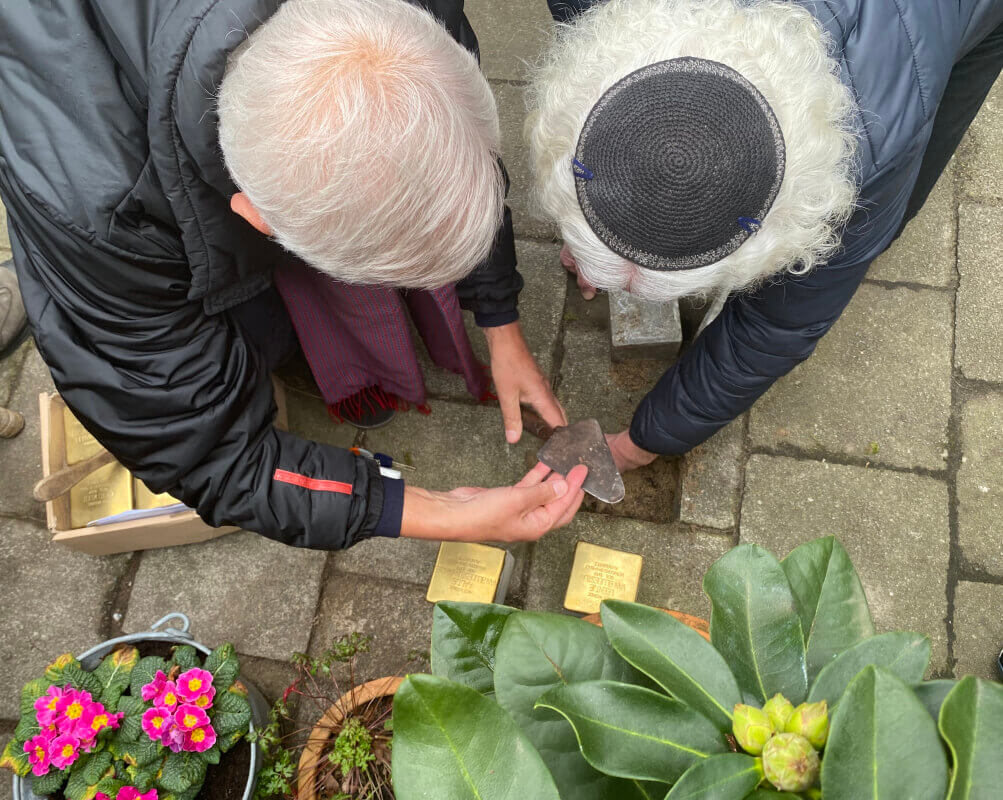 De twee steentjes op de Burmanstraat worden geplaatst (foto: Jim Terlingen)