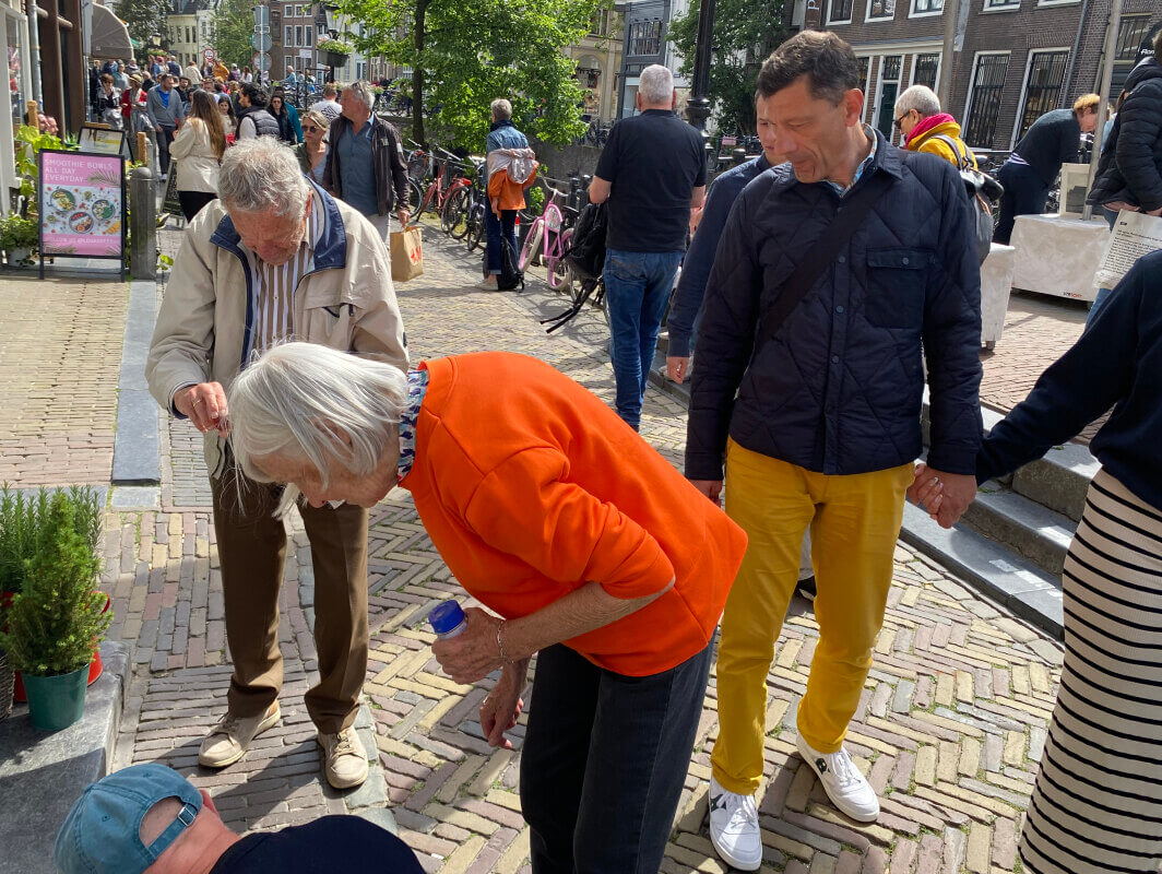 André (met beige jas), Jannie en Edward tijdens het poetsen. Passanten stoppen en kijken toe. Foto: JT