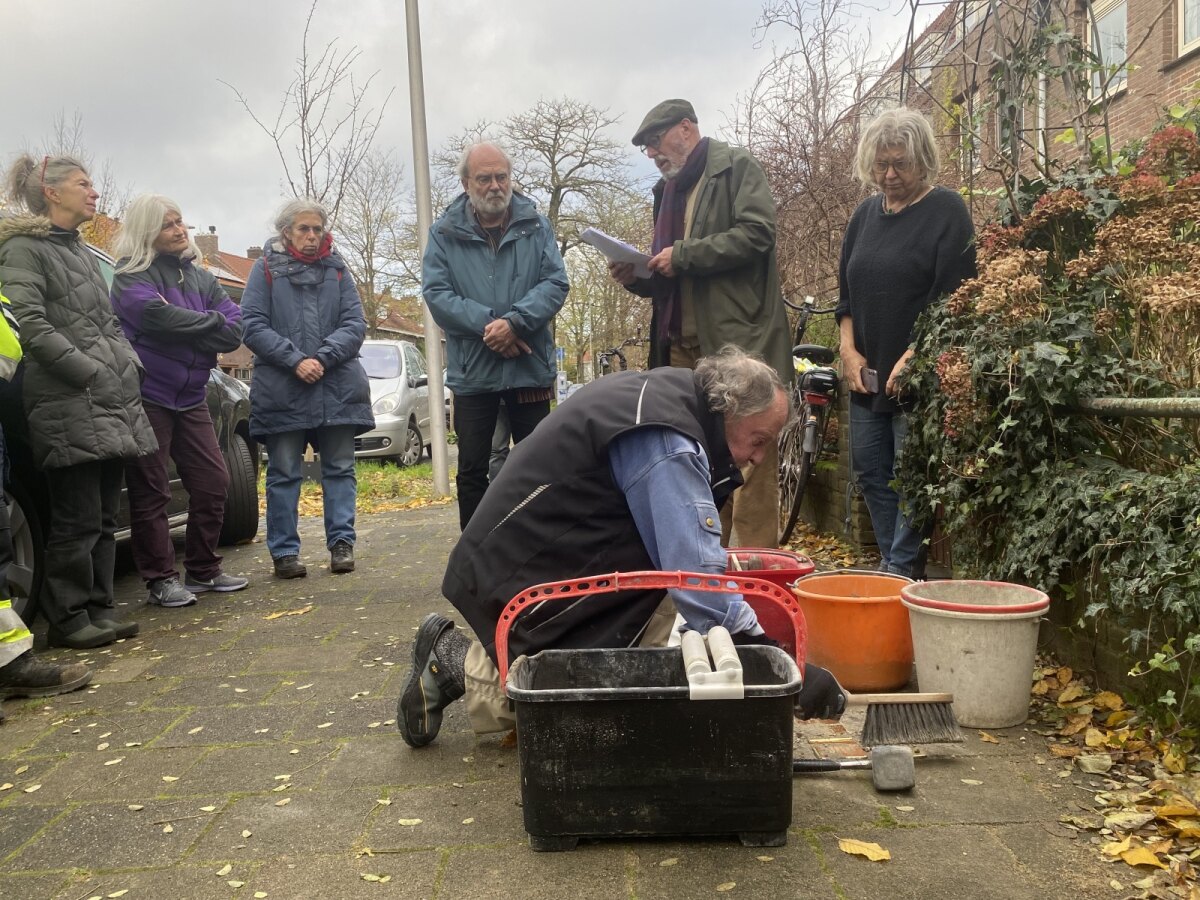 Terwijl Willem Spee een kleine toespraak houdt, plaatst Demnig op de Frans Halsstraat de stenen