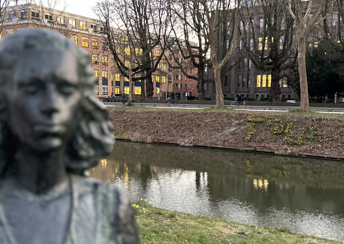 Links het beeld van Truus, rechts de bloemen op de nieuwe plek, 18 maart 2025. Foto: Jim Terlingen