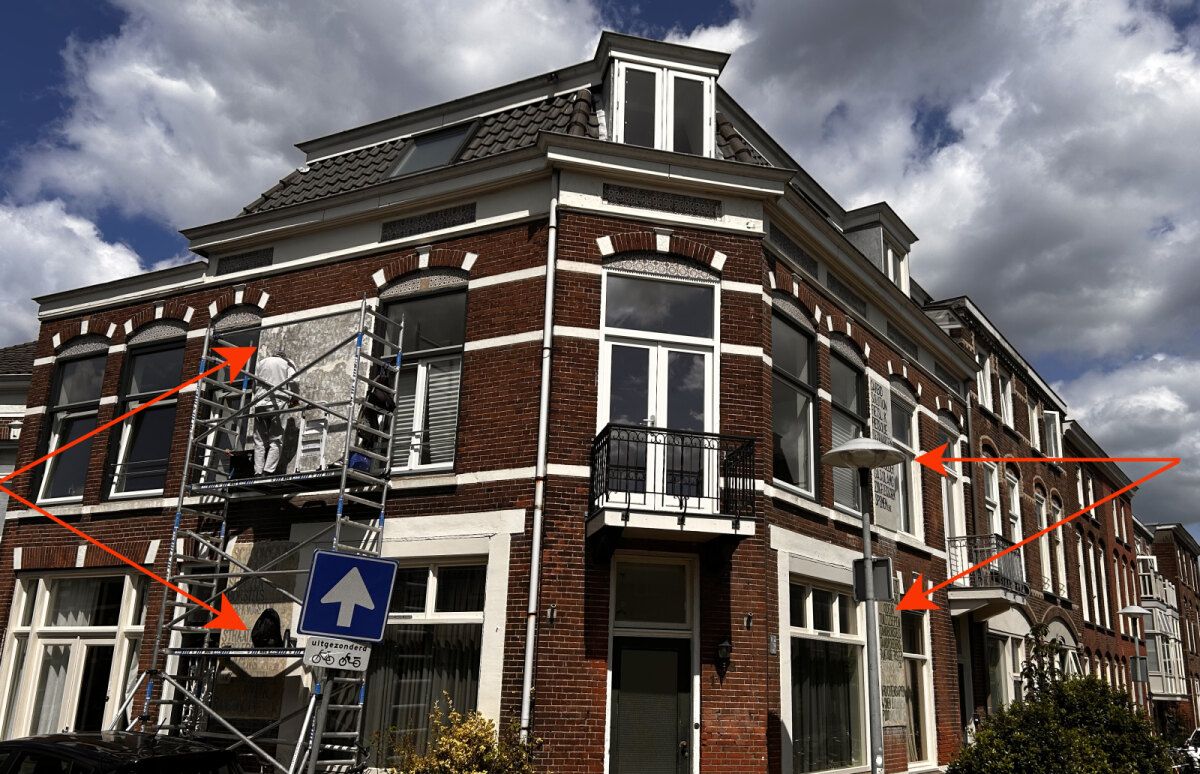 Op deze vier vlakken (zie rode pijlen) worden de muurreclames gerestaureerd