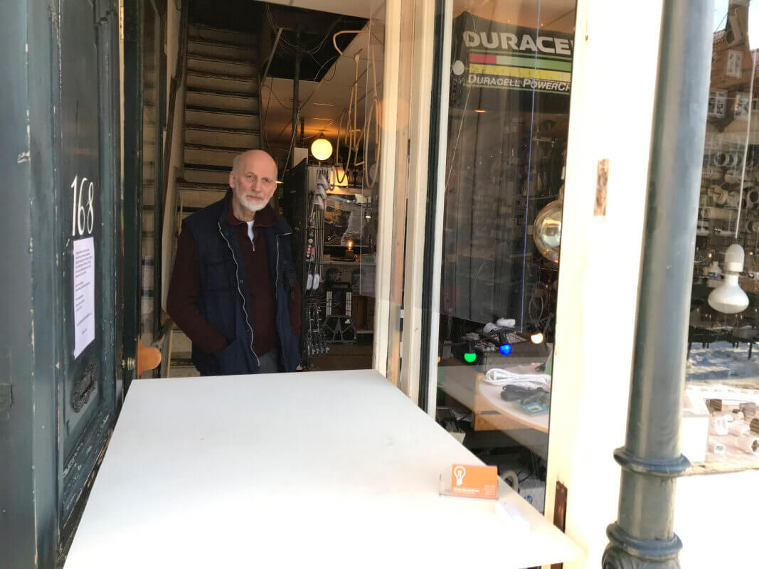 Piet van Willigenburg achter het afhaalloket van zijn winkel in februari 2021 (cornonatijd). Foto: Peter Notermans/HUA