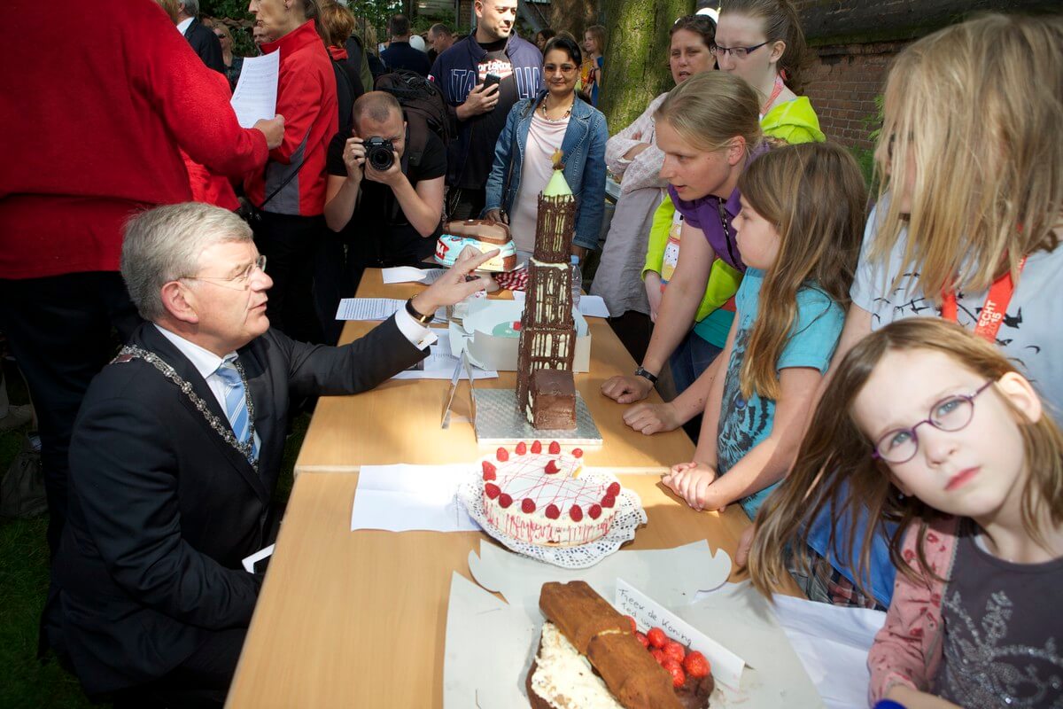 Burgemeester Van Zanen bekijkt de taarten.