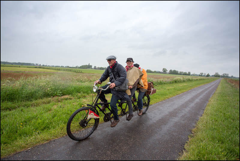 Drie belgen op één fiets tegen de wind in.