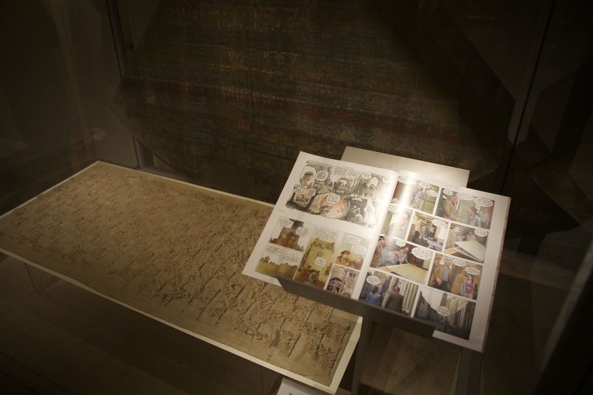 De halsdoek en het stripboek in een vitrine met op de achtergrond de koorkap van de heilige Bonifatius. Foto: Ton van den Berg