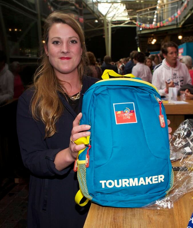 Een vrijwilligster showt de rugzak vol met Tourmakerskleding. Foto: Ton van den Berg