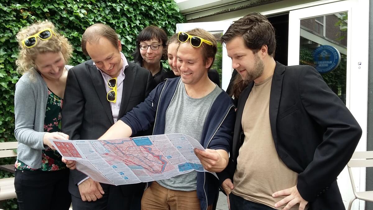 Wethouder Kreijkamp (2e van links) kijkt mee op de nieuwe internationale plattegrond. Foto: Toerisme Utrecht