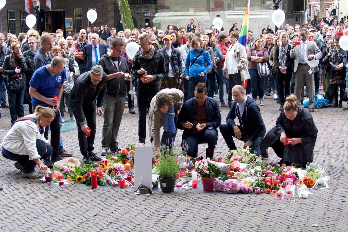 Bestuursleden van het Midzomergrachtfestival leggen bloemen en steken kaarsen aan. Foto: Ton van den Berg