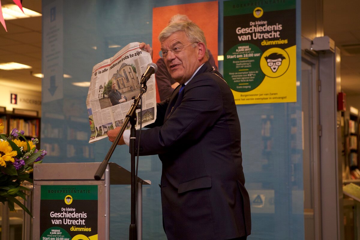 Burgemeester Van Zanen met de krant waarin een portret staat over Rene de Kam. Foto: Ton van den Berg