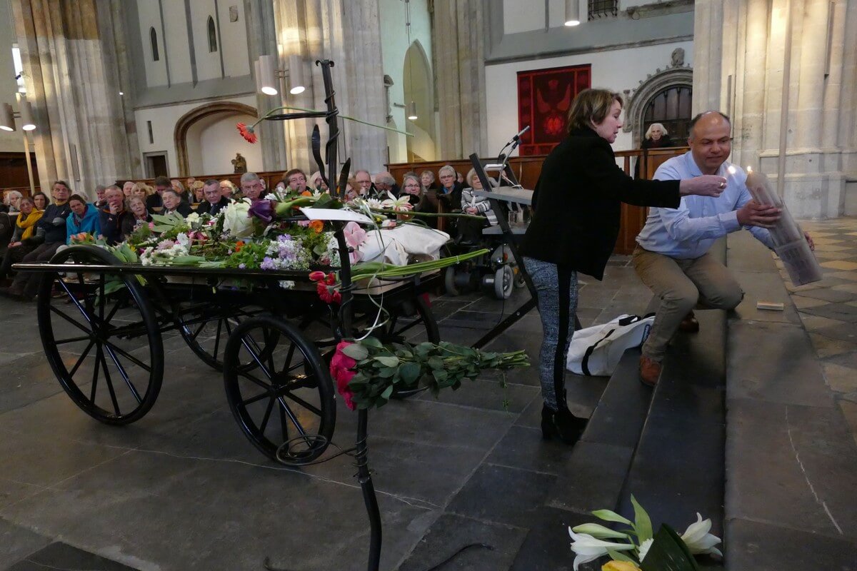 Ernest Alvares (Ruuds' rijschoolinstructeur) en Marijke (zus van Ruud) steken een Domtorenkaars aan. Foto: Ton van den Berg