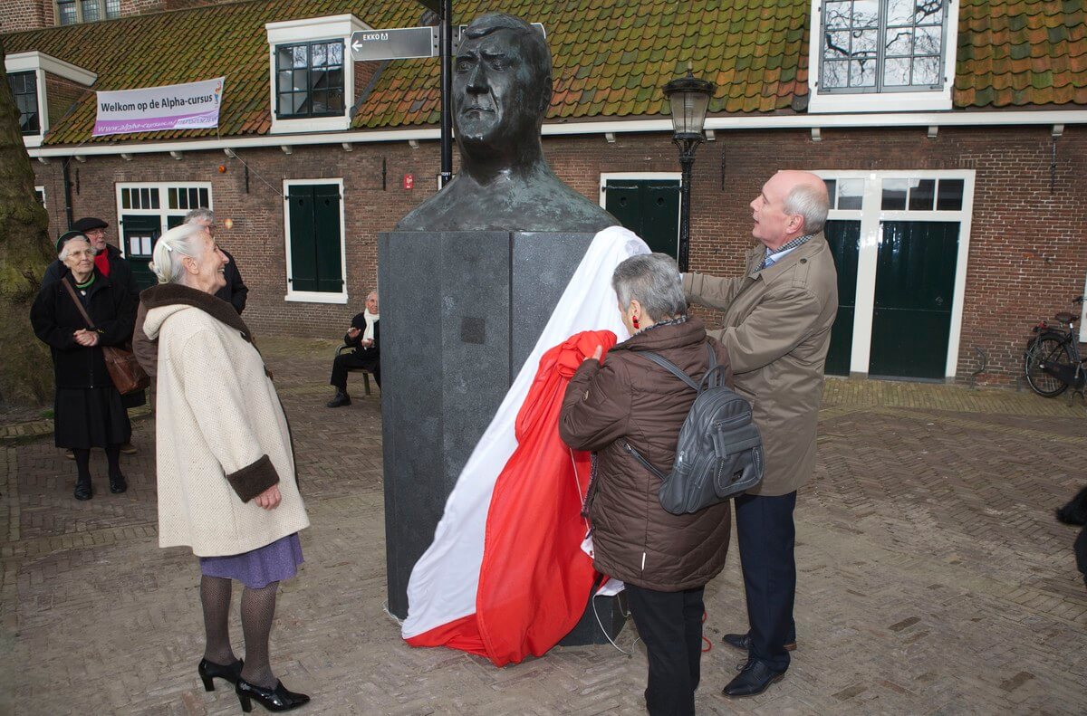 Jans Geesink kijkt tevreden naar het beeld nadat ze het beeld onthulde met Corrie Huiding en wethouder Geldof. Foto: Ton van den Berg