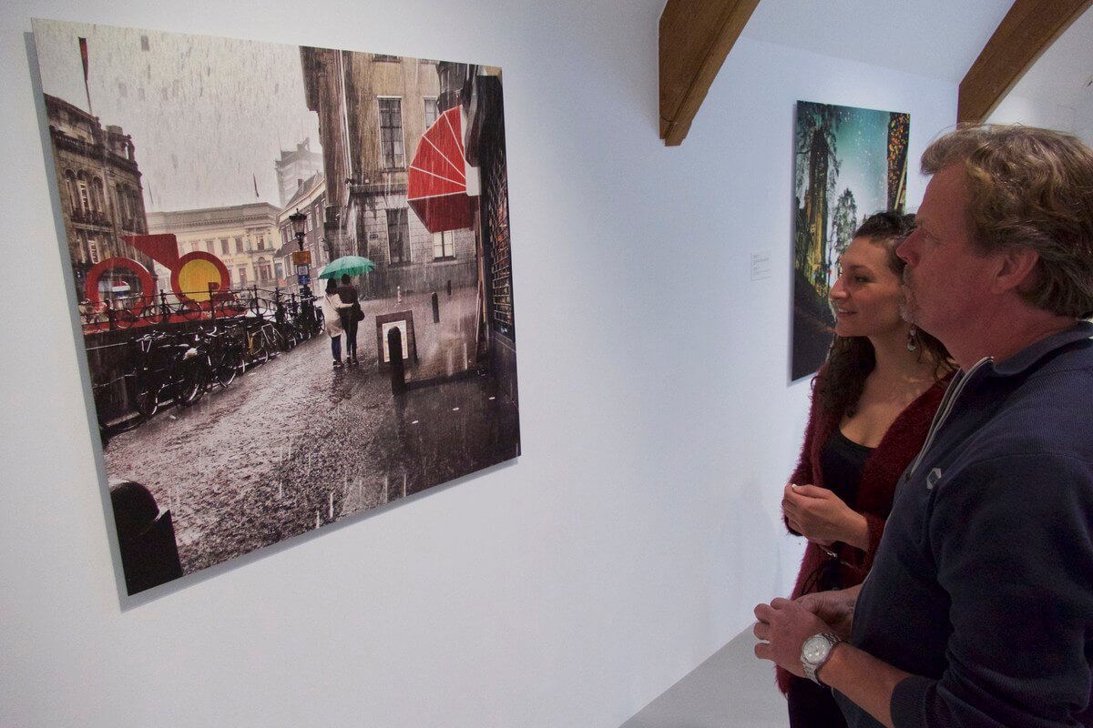 Joh Noy bekijkt een van de foto's van Wennekendonk. Foto: Ton van den Berg