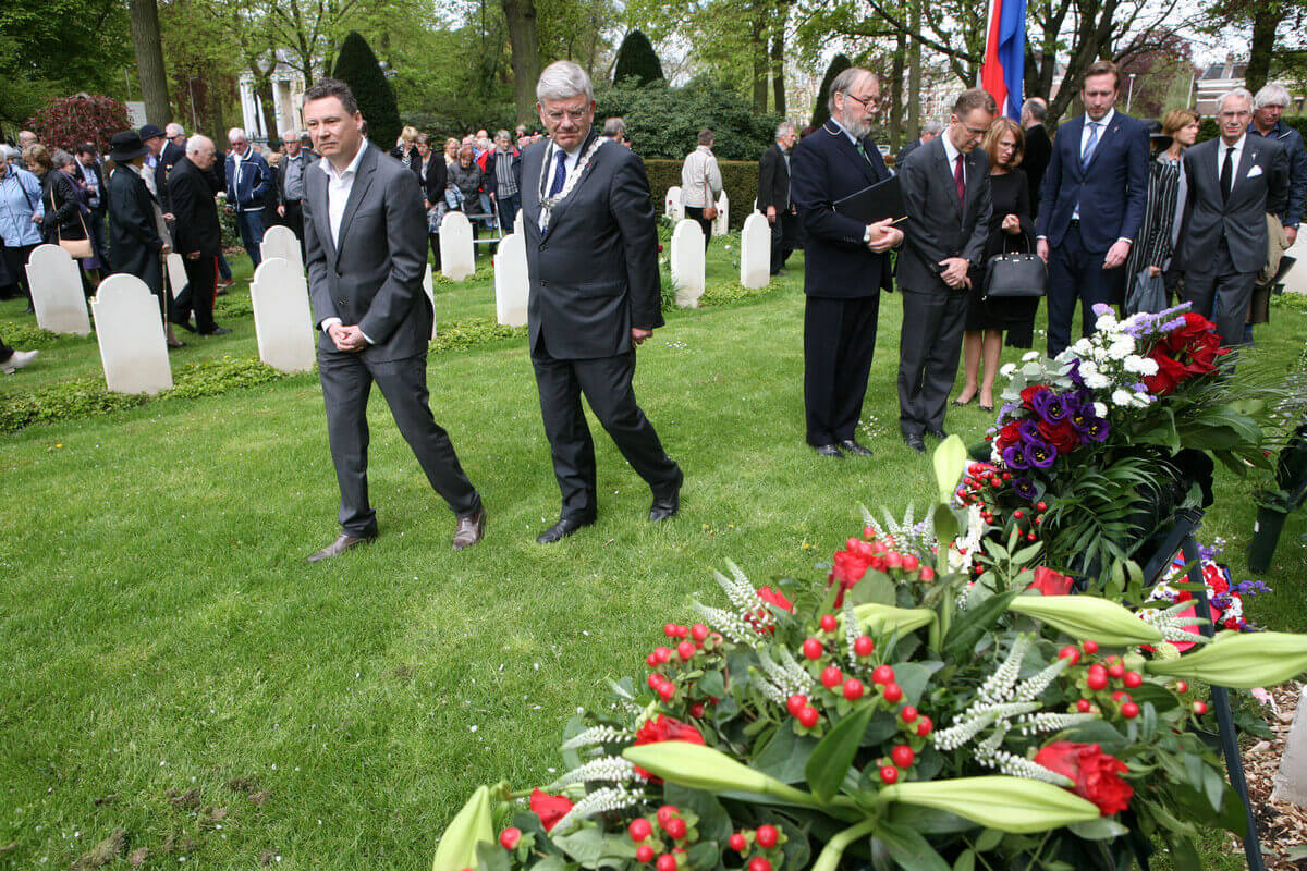 Burgemeester Van Zanen defileert met een van de nabestaanden, de heer Toussaint, langs het monument voor oorlogsslachtoffers (rechts van hem Thomas Dres). Foto: Ton van den Berg