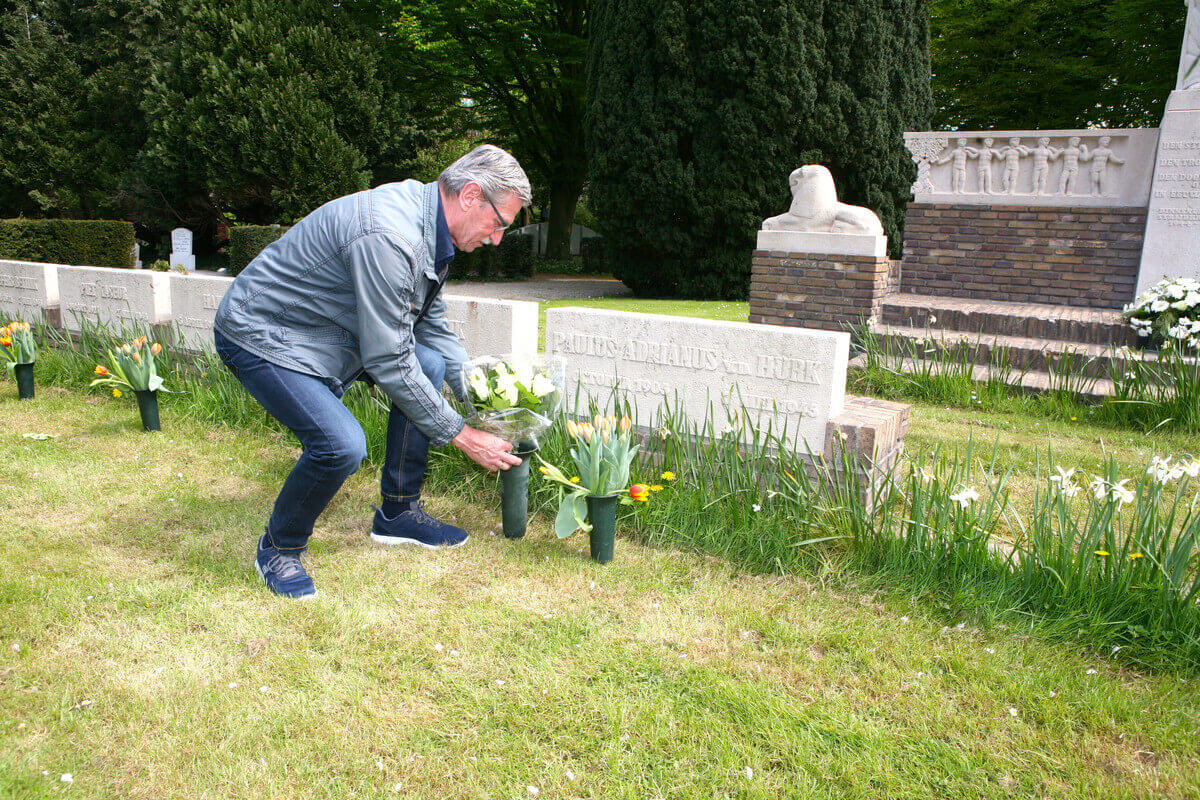 Paul van den Hurk legt bloemen bij het graf van zijn vader die op 7 mei 1945 omkwam. Foto: Ton van den Berg